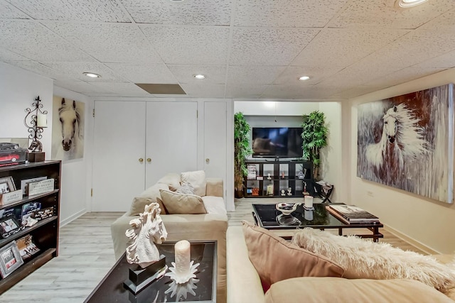 living room featuring recessed lighting, a drop ceiling, and wood finished floors