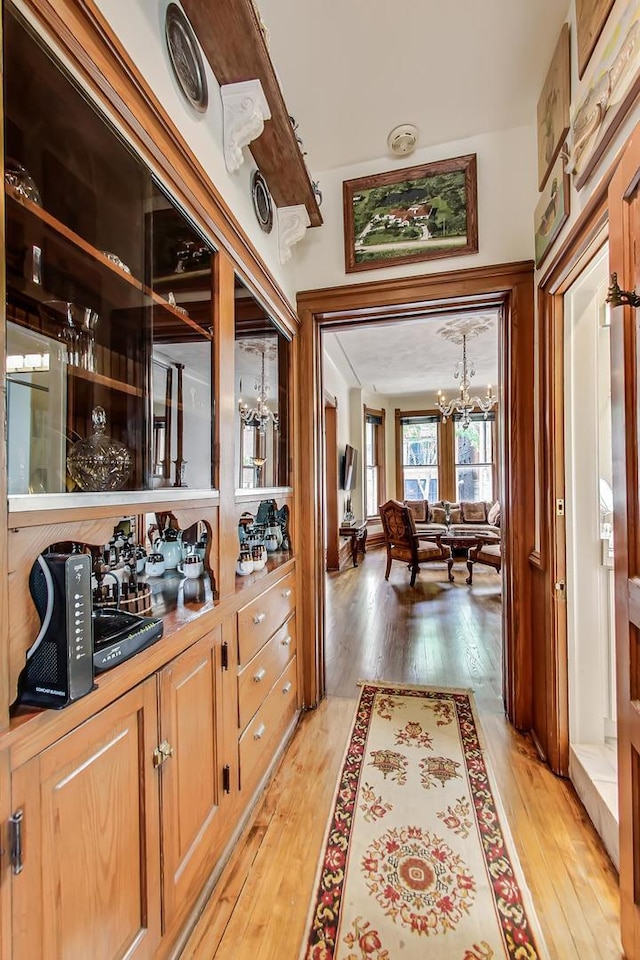 hall with a chandelier and light wood finished floors