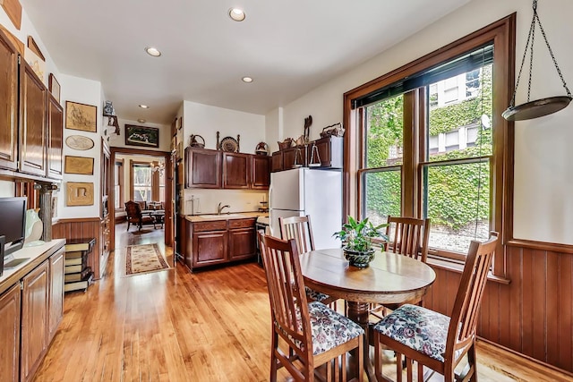 dining room with light wood-style flooring and a healthy amount of sunlight