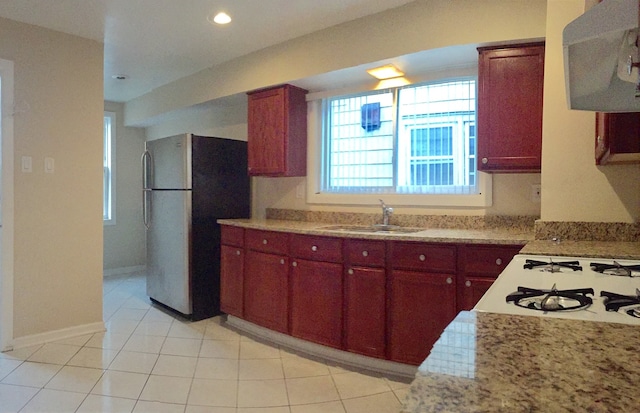 kitchen featuring extractor fan, recessed lighting, a sink, freestanding refrigerator, and cooktop