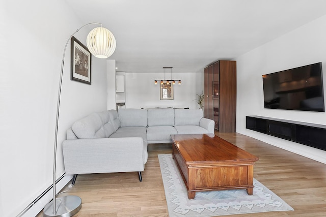 living room featuring a baseboard heating unit and light wood finished floors