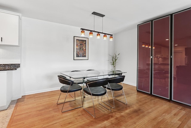 dining area with baseboards and light wood-style floors