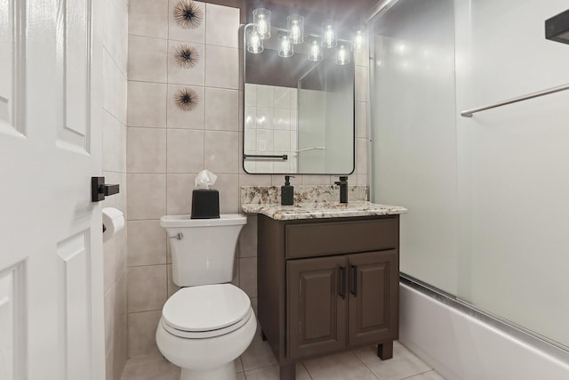 full bath featuring tub / shower combination, toilet, vanity, tile patterned floors, and tile walls