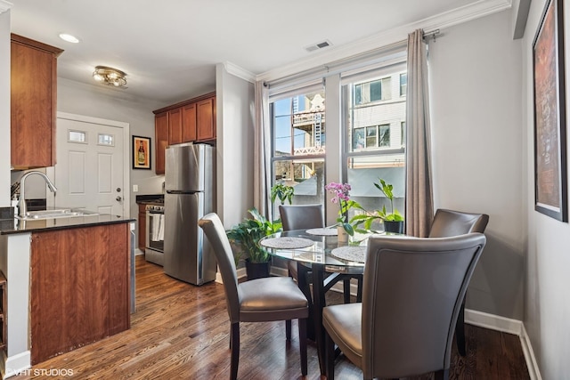 dining room with recessed lighting, dark wood-type flooring, visible vents, baseboards, and ornamental molding