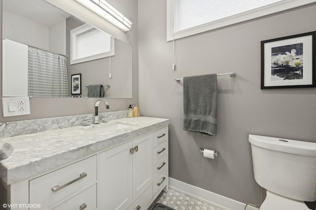 bathroom featuring curtained shower, vanity, toilet, and baseboards