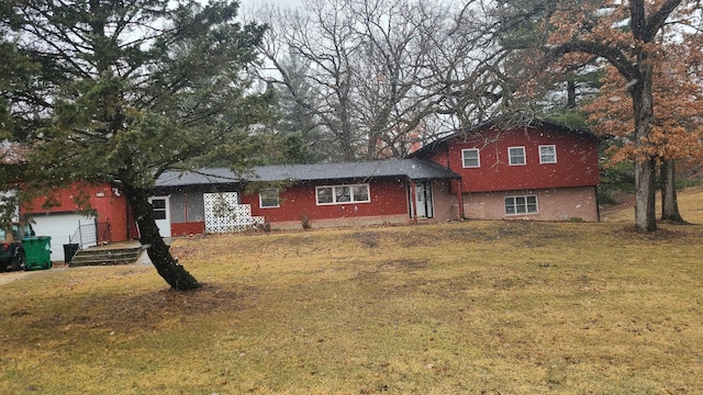 tri-level home with a garage, a front yard, and brick siding