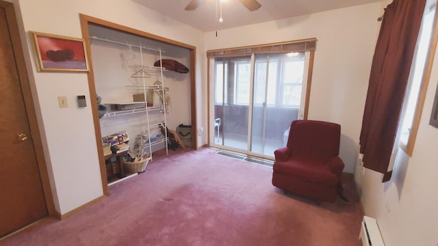 living area featuring a baseboard heating unit, ceiling fan, and carpet flooring