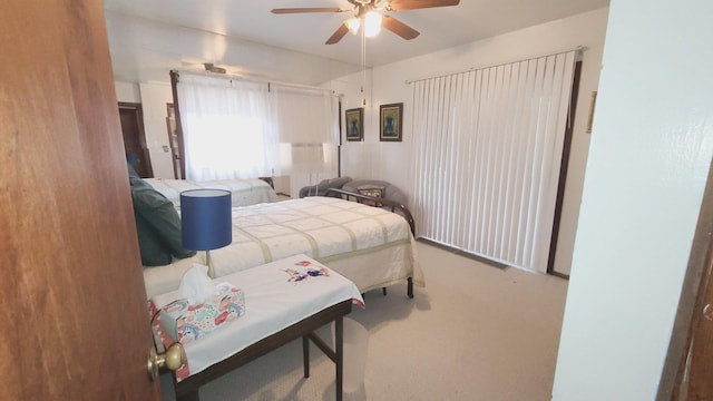 bedroom with a ceiling fan and carpet