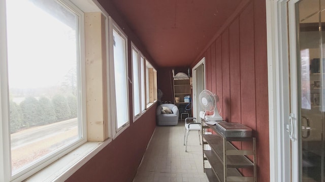 hallway featuring wooden walls