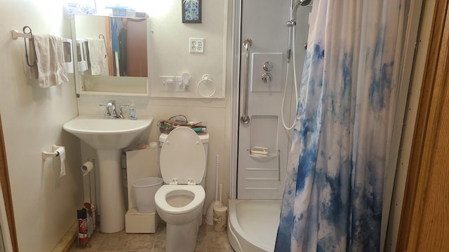 full bath featuring a stall shower, tile patterned flooring, a sink, and toilet