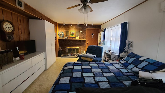 bedroom featuring a brick fireplace, visible vents, ceiling fan, and brick wall