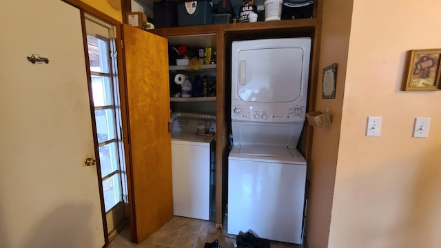 laundry room featuring laundry area, tile patterned flooring, and stacked washer / dryer