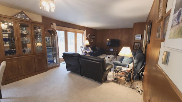 carpeted living room with wood walls