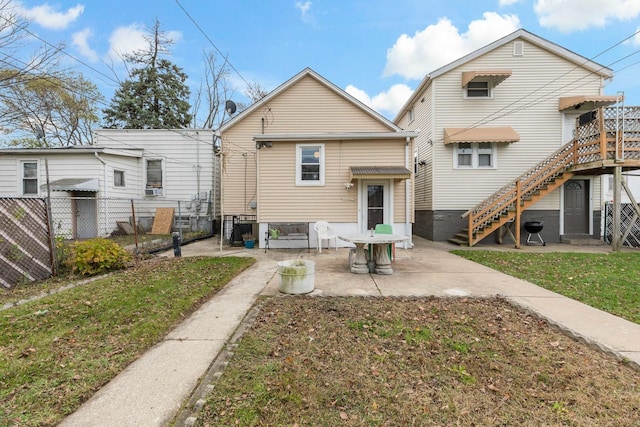 rear view of property featuring a patio area, fence, and a lawn