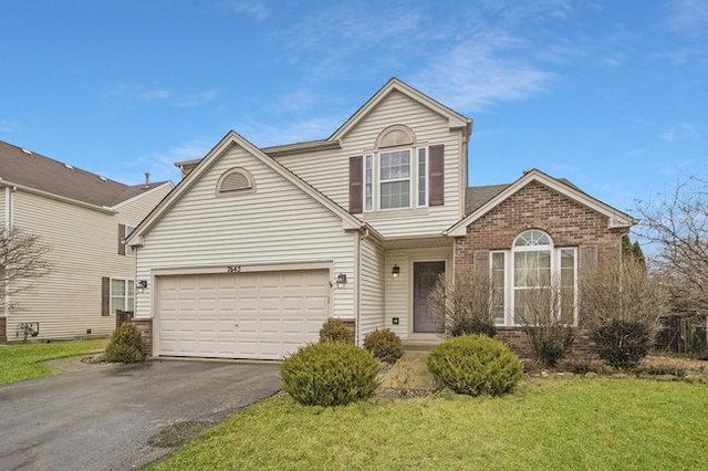 traditional-style house featuring a front yard, brick siding, driveway, and an attached garage