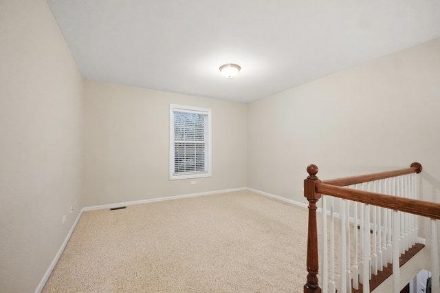 carpeted empty room featuring baseboards