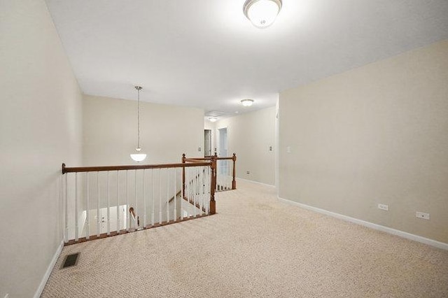 unfurnished room featuring carpet, visible vents, and baseboards