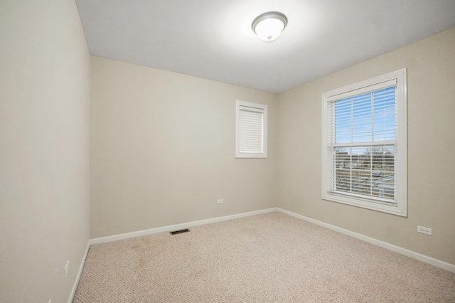 carpeted empty room with baseboards