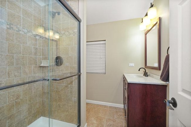 bathroom with tile patterned floors, a shower stall, vanity, and baseboards