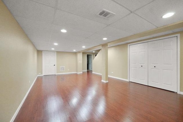 finished below grade area featuring visible vents, baseboards, and wood finished floors