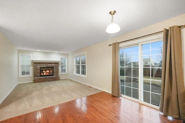 unfurnished living room with baseboards, a fireplace, and hardwood / wood-style floors