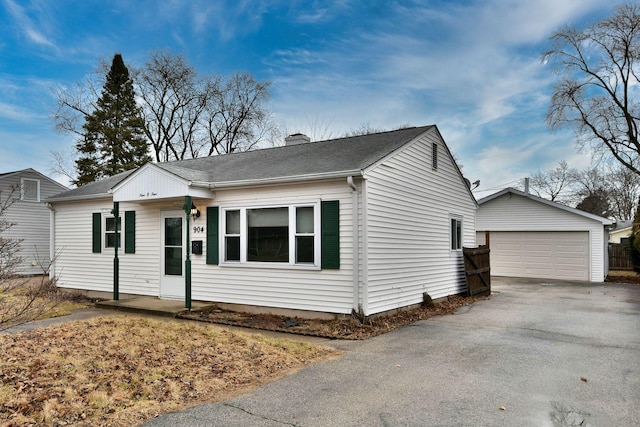 view of front of home with a garage, an outbuilding, a shingled roof, and a chimney