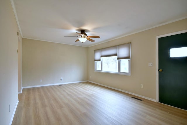 spare room featuring ceiling fan, ornamental molding, light wood-style flooring, and baseboards