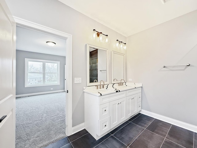 bathroom featuring double vanity, baseboards, a sink, and tile patterned floors