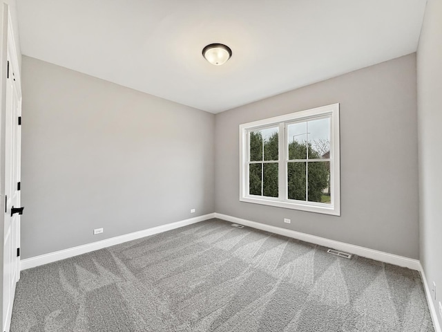 carpeted spare room featuring visible vents and baseboards