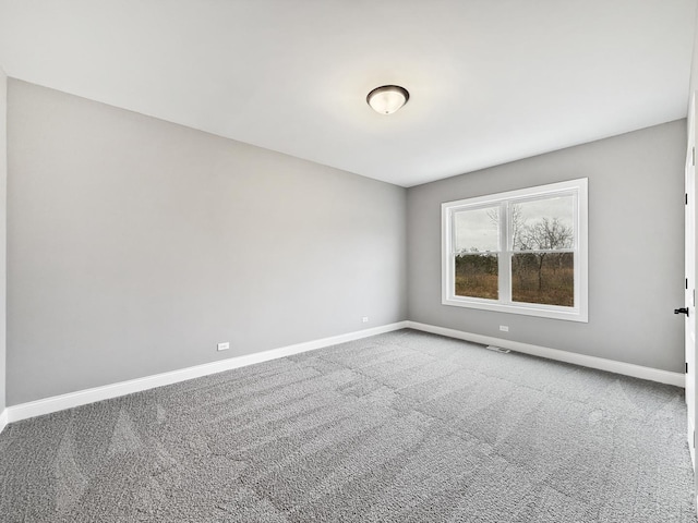 unfurnished room featuring carpet flooring, visible vents, and baseboards