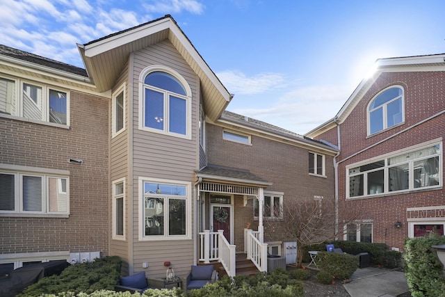 view of front of house with central air condition unit and brick siding