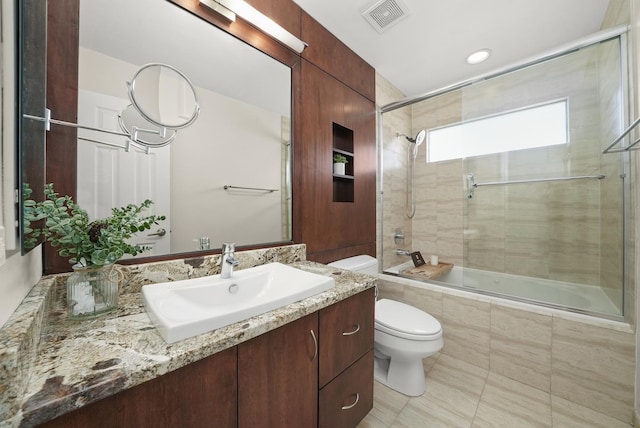 bathroom featuring vanity, toilet, visible vents, and tiled shower / bath combo