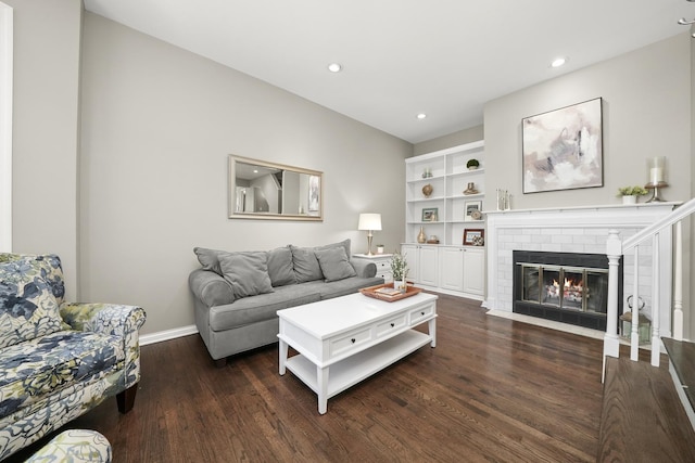 living room with built in features, dark wood-style floors, recessed lighting, a fireplace, and baseboards