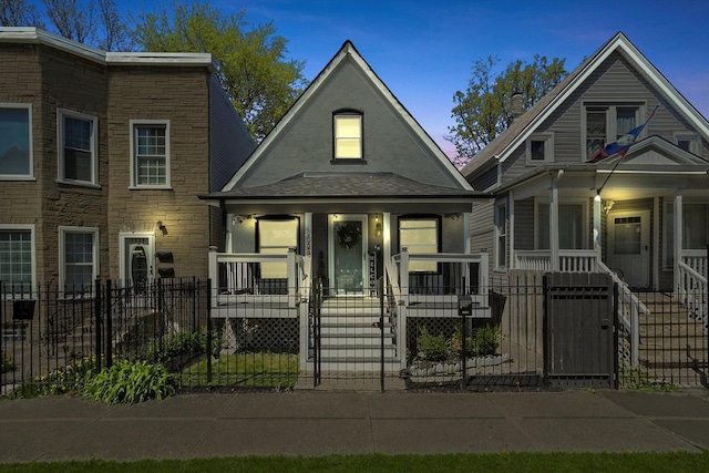 view of front of house featuring covered porch, a fenced front yard, and a gate