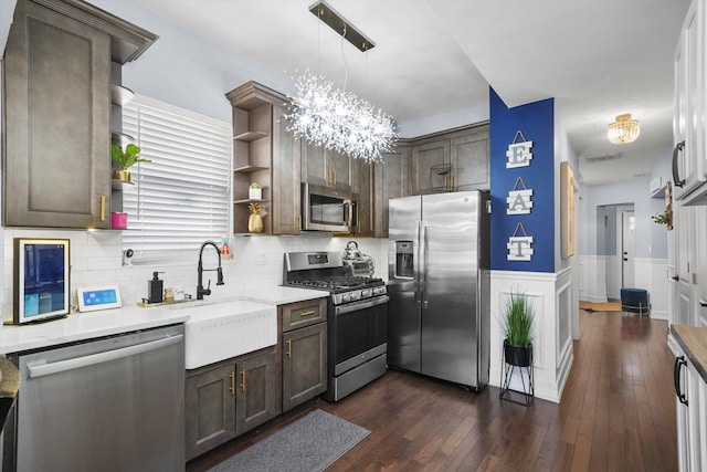 kitchen featuring stainless steel appliances, wainscoting, dark brown cabinets, and open shelves