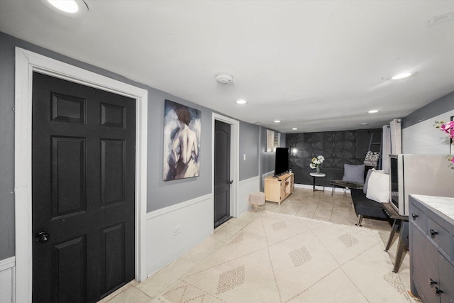 hallway with recessed lighting, a wainscoted wall, and wallpapered walls