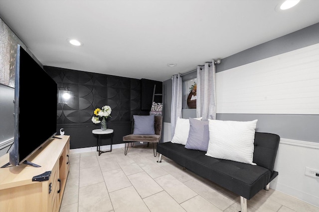 sitting room featuring light tile patterned floors, recessed lighting, an accent wall, baseboards, and wallpapered walls