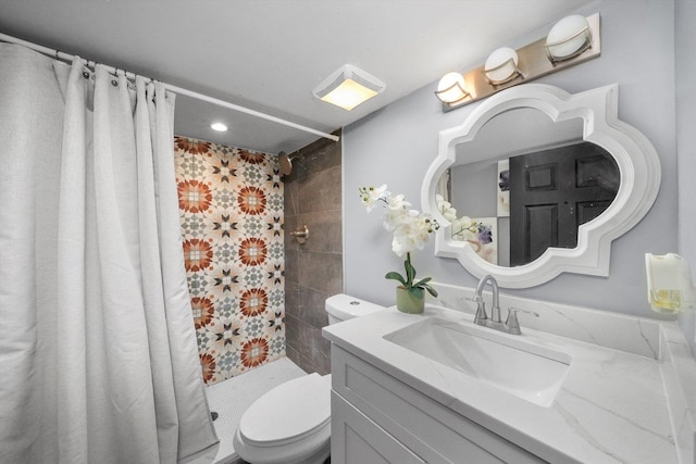 bathroom with visible vents, vanity, a tile shower, and toilet