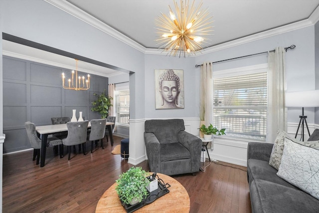 living room with a chandelier, wood finished floors, a decorative wall, and ornamental molding