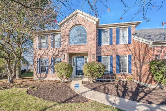 colonial inspired home featuring brick siding