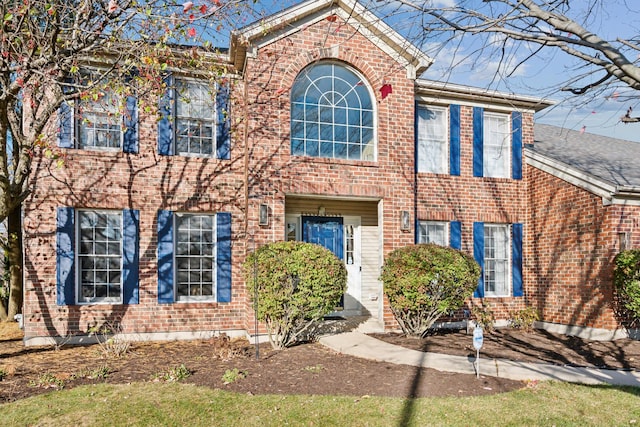 colonial inspired home featuring brick siding