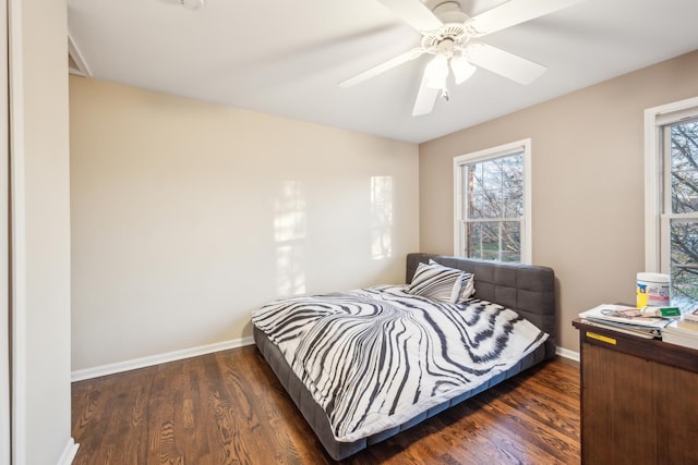 bedroom with multiple windows, baseboards, and wood finished floors