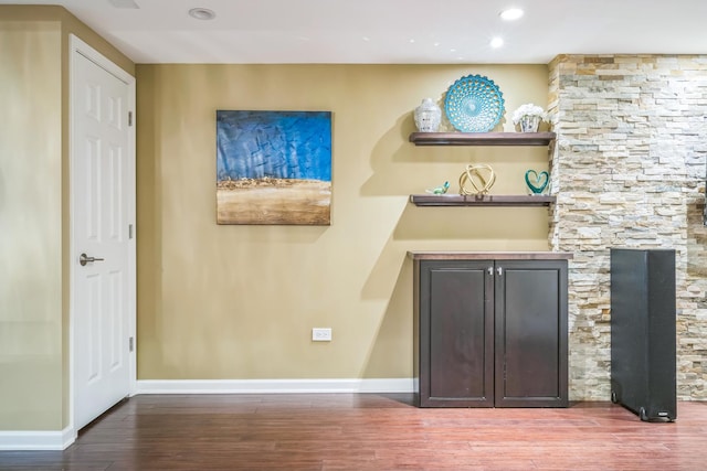 bar featuring baseboards, wood finished floors, and recessed lighting