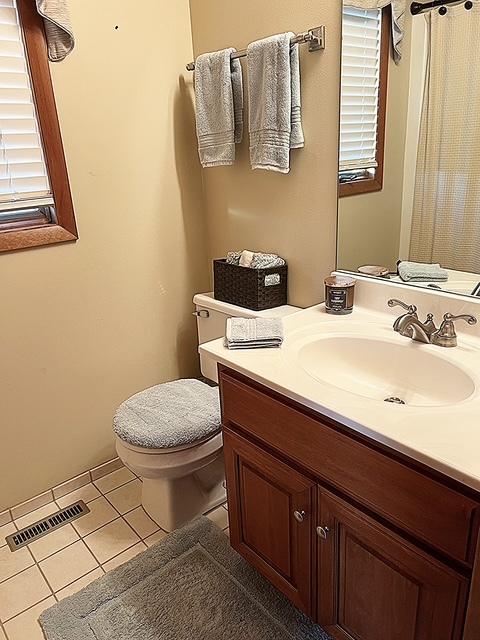 bathroom featuring toilet, tile patterned floors, visible vents, and vanity