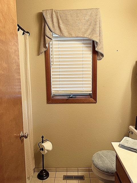 bathroom featuring toilet, vanity, baseboards, visible vents, and tile patterned floors