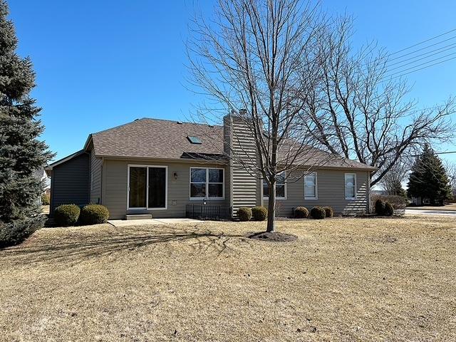 rear view of house featuring a lawn