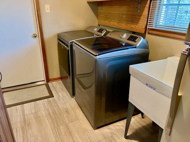 clothes washing area featuring laundry area and washer and clothes dryer