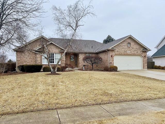 ranch-style house featuring driveway, a front lawn, an attached garage, and brick siding