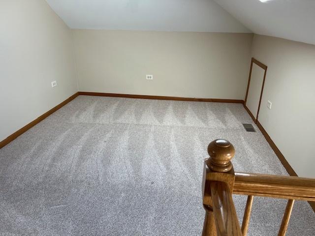 bonus room featuring lofted ceiling, carpet, visible vents, and baseboards