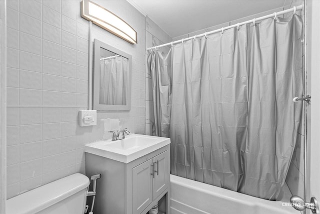 full bathroom with toilet, shower / tub combo, tile walls, and vanity